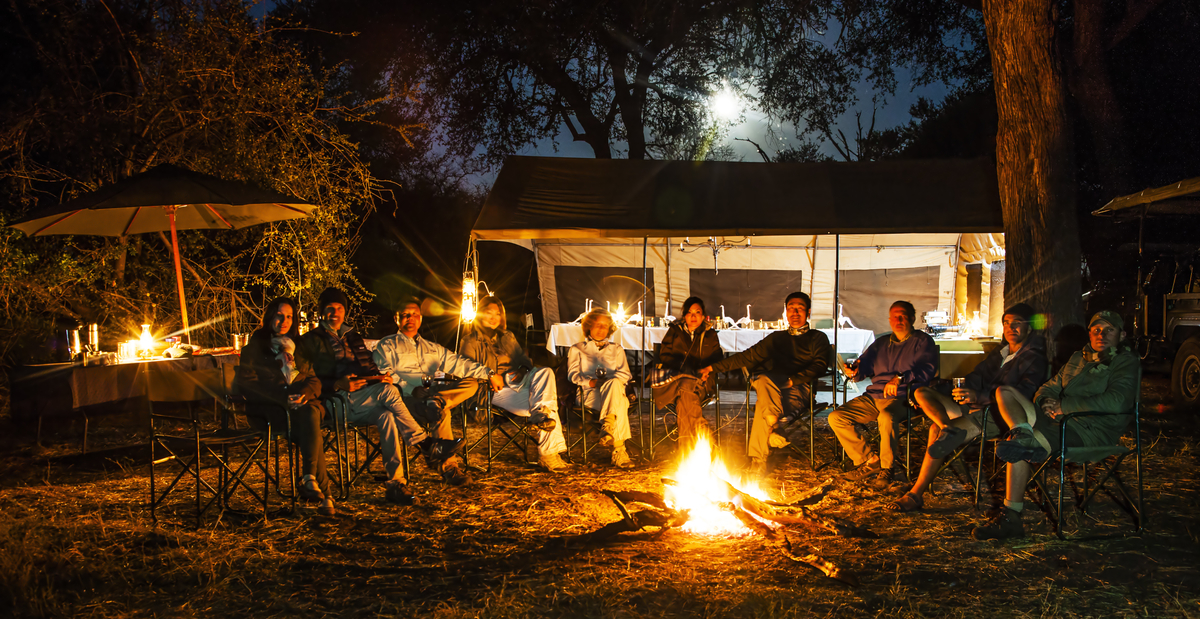 Capture Africa group dining around the campfire