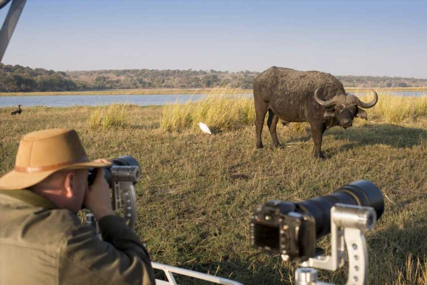 A photo-crazed traveller in action on one of andBeyond's photographic safaris in Botswana – courtesy of andBeyond